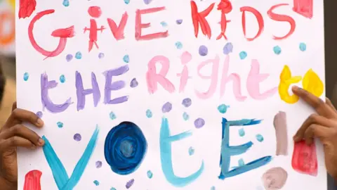Getty Images Give kids the right to vote placard
