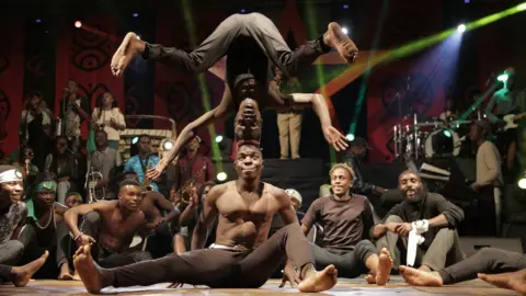 EPA In Zimbabwe, a group of acrobats perform for a captive audience during the annual Harare International Festival of the Arts (Hifa) on 1 May 2018