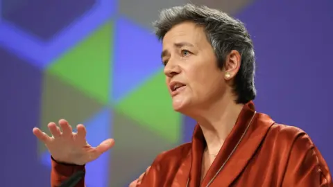 Getty Images Margrethe Vestager gestures as she speaks from a podium