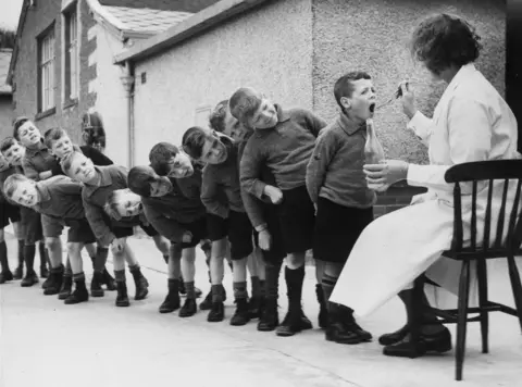 Getty Images Boys in a medicine queue