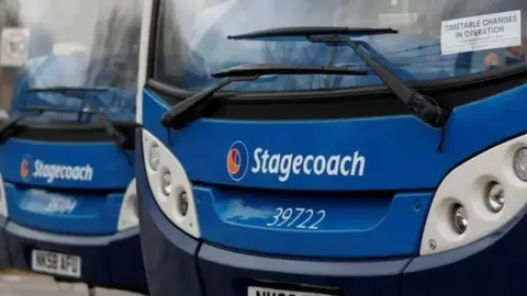 Two blue Stagecoach buses are parked next one another with the close-up photo capturing the front of the vehicles only.