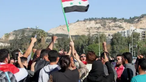 EPA Syrians show support for President Assad after US-led air strikes in response to a suspected chemical weapons attack blamed on the government, 14 April 2018