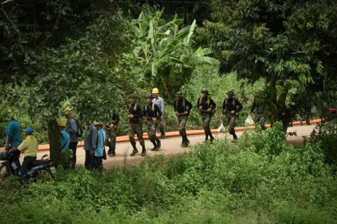 AFP Thai soldiers run down the road leading to the Tham Luang cave