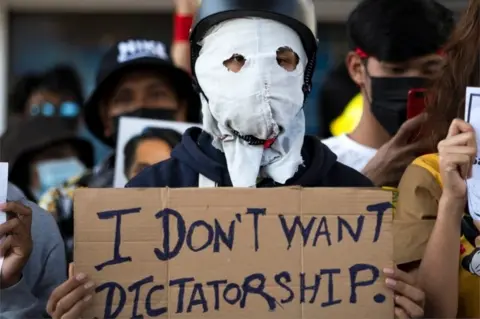 Reuters A demonstrator holds a placard during a rally against the military coup and to demand the release of elected leader Aung San Suu Kyi, in Yangon, Myanmar, February 10, 2021.