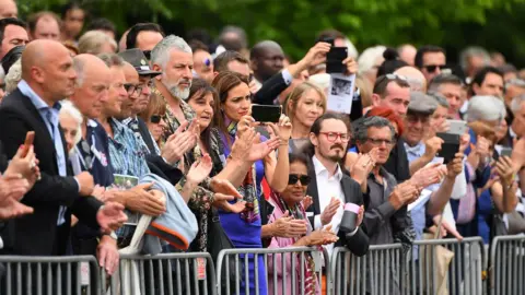 Getty Images A crowd of mourners applaud as Sisto Malaspina's hearse leaves the church where his funeral service was held