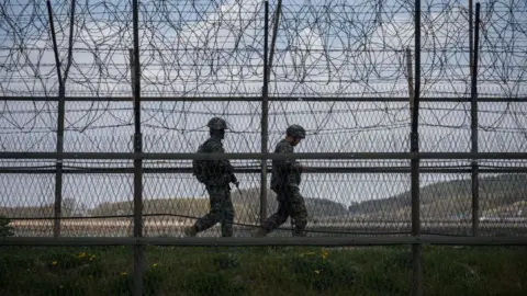 Getty Images South Korean soldiers patrol along a barbed wire fence Demilitarized Zone (DMZ) separating North and South Korea, on the South Korean island of Ganghwa on April 23, 2020.