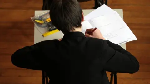 David Davies/PA Wire Boy sitting a test at a desk