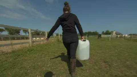 Heather McMillan carrying water