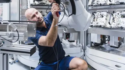 Man with industrial robot - stock photo