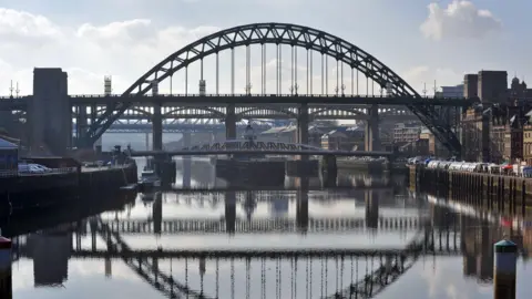 The Tyne Bridge with its reflection in he water and the High Level Bridge behind 