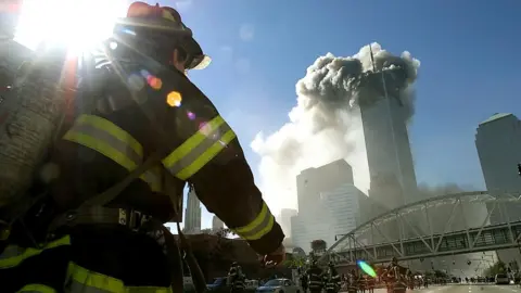 Firefighters walk towards one of the tower at the World Trade Center before it collapsed after a plane hit the building September 11, 2001 in New York City.