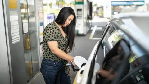 Getty Images Woman filling up car at petrol pump