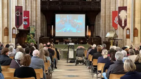 People watching a big screen in Beverley Minster