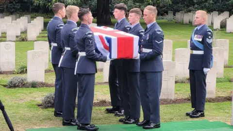 Ministry of Defence Personnel from the Queen’s Colour Squadron bear the remains of the crew of Leading Aircraftman John Stuart Mee Bromley to his final resting place