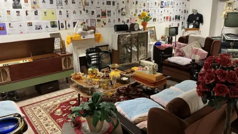 Jon Wright/BBC A living room layout with 1940s furniture, with sofas and a coffee table in the centre.