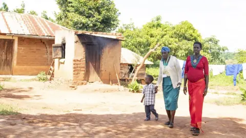 African Academy of Sciences A traditional birth attendant walks with a pregnant mother