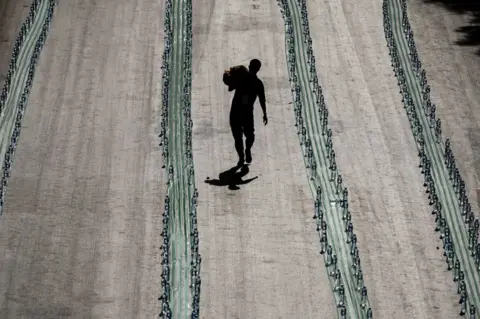 AFP A Muslim volunteer walks past long rows of plastic bottles.
