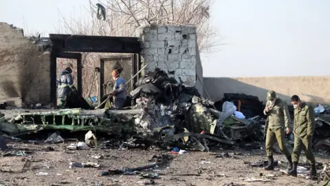 EPA People stand near the wreckage after a Ukrainian plane carrying 176 passengers crashed near Imam Khomeini airport in Tehran on January 8, 2020