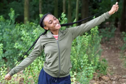 BBC Michaela holding out her braids