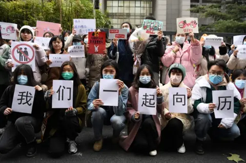 AFP Supporters of Zhou Xiaoxuan display posters outside the Haidian District Peoples Court in Beijing on December 2, 2020