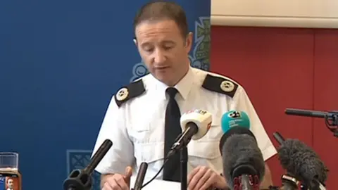 Police officer in front of microphones