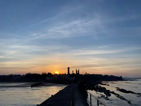 Emily Malcolm A sunset over St Andrews, with water lapping around the beach