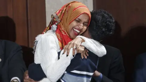 EPA Ilhan Omar hugs her son after being sworn into Congress