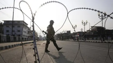 EPA Indian military in front of barbed wire fence