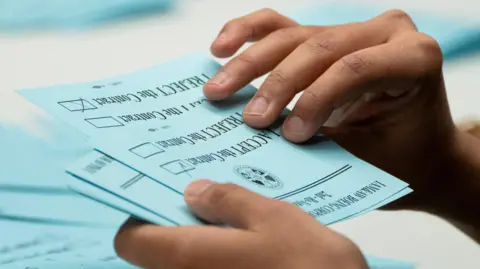 Reuters A union member from the International Association of Machinists and Aerospace Workers District 751 counts ballots after a vote on a new contract proposal from Boeing at a union hall during an ongoing strike in Seattle, Washington, US 4 November, 2024. 