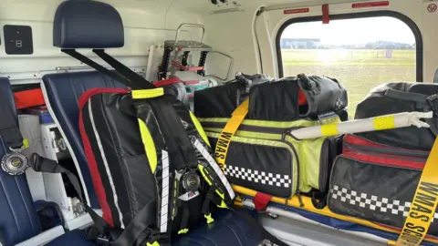 Ollie Conopo/BBC Equipment packed in bags inside a helicopter. A seat is also visible.