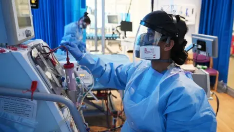 PA Media Clinical staff wear Personal Protective Equipment (PPE)