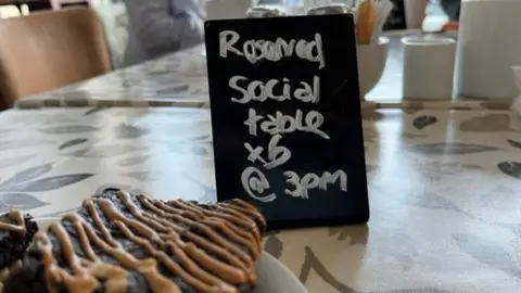 BBC Photo of social table sign and cake