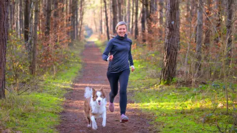 Getty Images Woman running with a dog