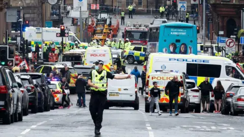 Getty Images Looking down St Vincent Street in Glasgow city centre - there is a large number of emergency vehicles blocking the road with an area outside the Park Inn hotel cordoned off