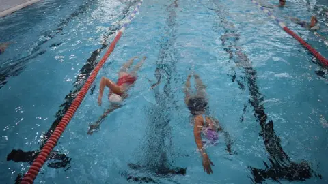 Getty Images/DANIEL LEAL Swimmers in pool