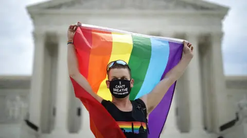 Getty Images A demonstrator with a Pride Flag standing in front of the US Supreme Court in June 2020