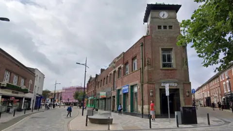 A street in Wolverhampton city centre with several shops and a pub.
