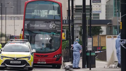 PA Media Bus and police car at the scene of the stabbing