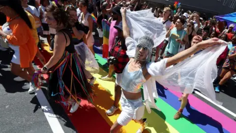 ESA ALEXANDER/REUTERS Participants parade through the streets during the annual Cape Town Pride celebrations, in Green Point, South Africa, March 2, 2024