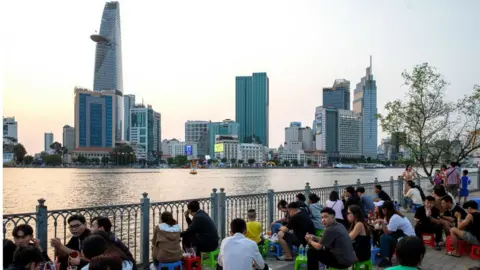 Getty Images People relax on the bank of Saigon River in Ho Chi Minh City, Vietnam, on Sunday, February 25, 2024.