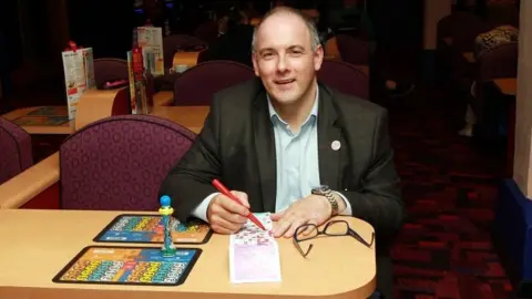 PA Media Robert Halfon playing bingo in Harlow