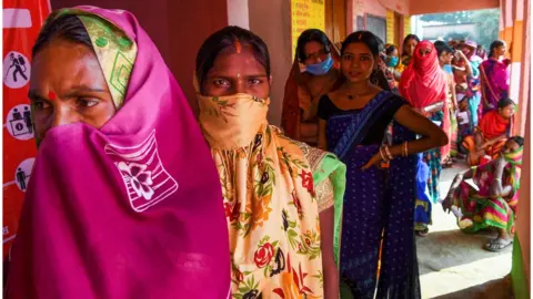 Getty Images Indian women queue to vote at a polling station