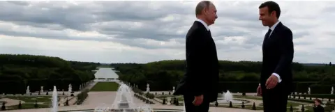 Reuters French President Emmanuel Macron (R) and Russian President Vladimir Putin pose in the gardens of the Versailles Palace following their meeting in Versailles, near Paris, France, May 29