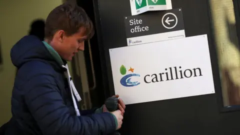 Reuters Carillion worker removes sign