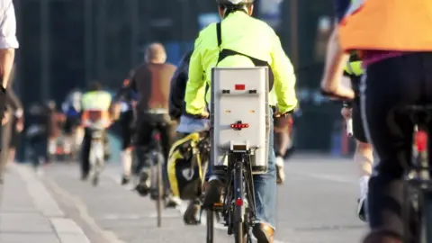 Getty Images Cycling commuters on a busy road