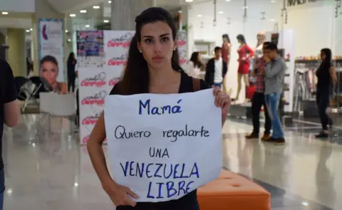 Gabriela Sayago holds up a protest sign