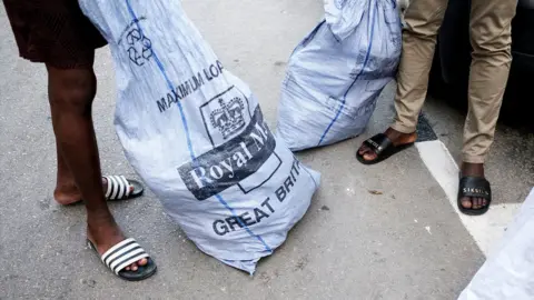 BBC/Joanna Demarco Sacks of letters arrive weekly for Lamin, Abdalla and Abdul