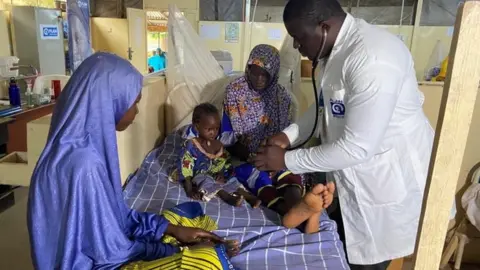 Getty Images Dr. Japhet Udokwu attends to a child at a treatment center for severely malnourished children in Damaturu, Yobe, Nigeria August 24, 2022