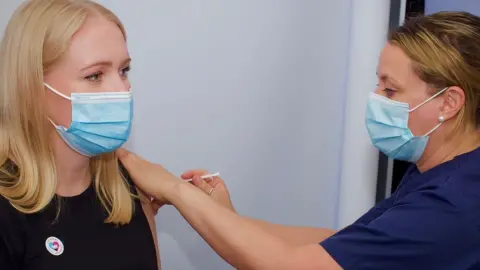 Martin Giles/BBC Jessica Sims being vaccinated.