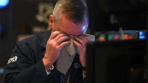 AFP A trader wipes his brow on the NYSE floor